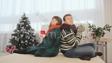 一对相爱的夫妇正背靠背坐在一起喝热咖啡。 <strong>平安</strong>夜。 温暖的新年`气氛。